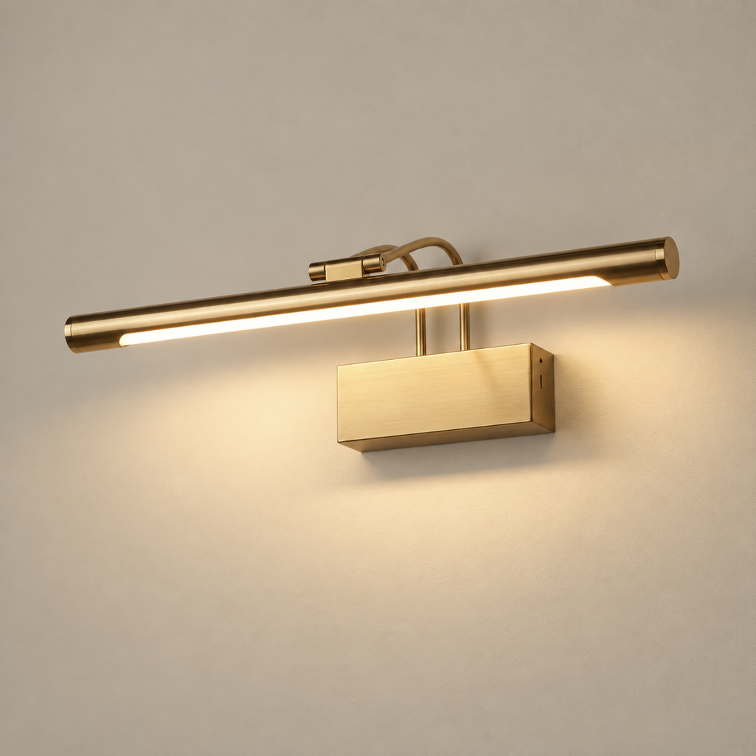 Arden cordless rechargeable LED picture light in brushed gold, lit, on a greige wall