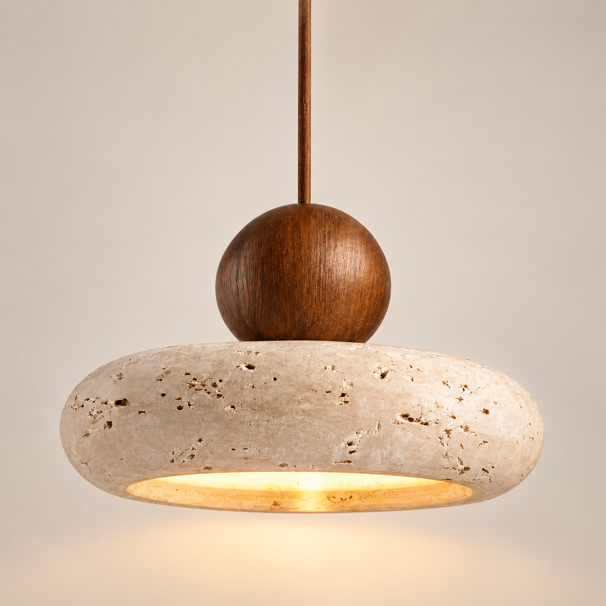 Aurelia stone and walnut wood pendant light, lit, on a greige studio background