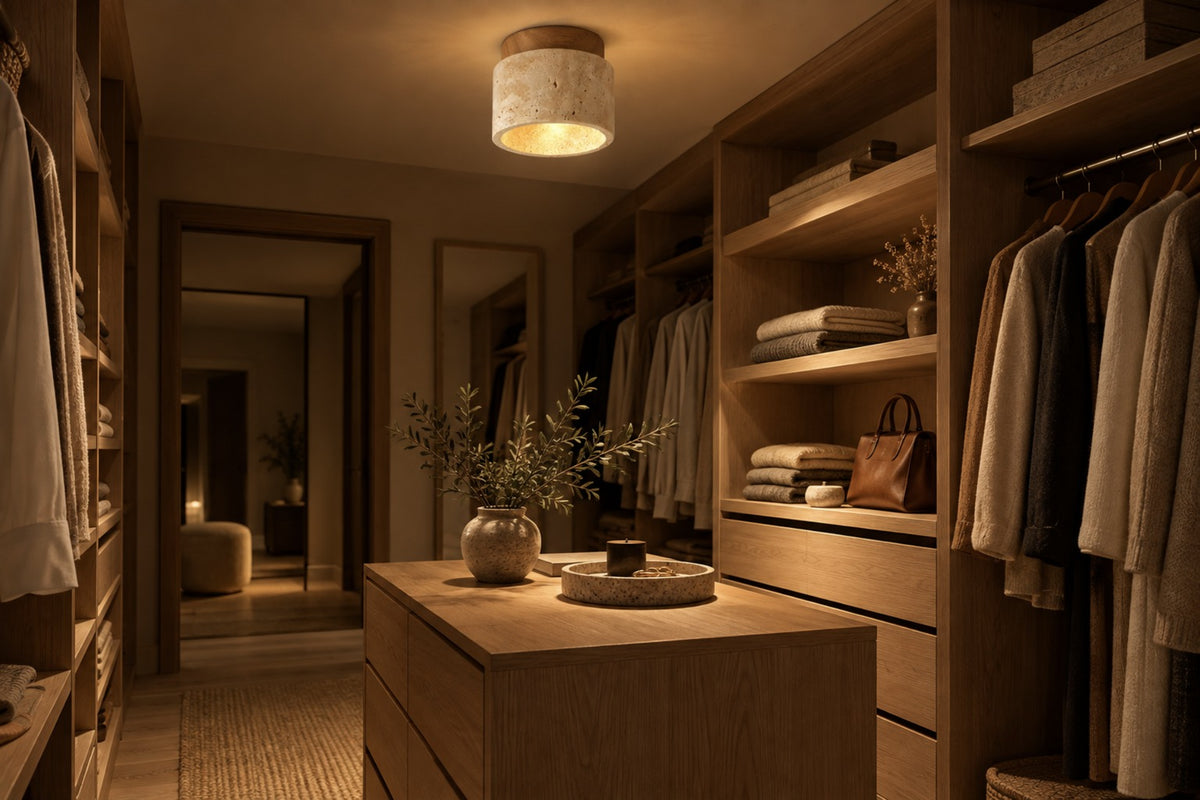 Calvera travertine ceiling light glowing in an oak walk-in wardrobe at night
