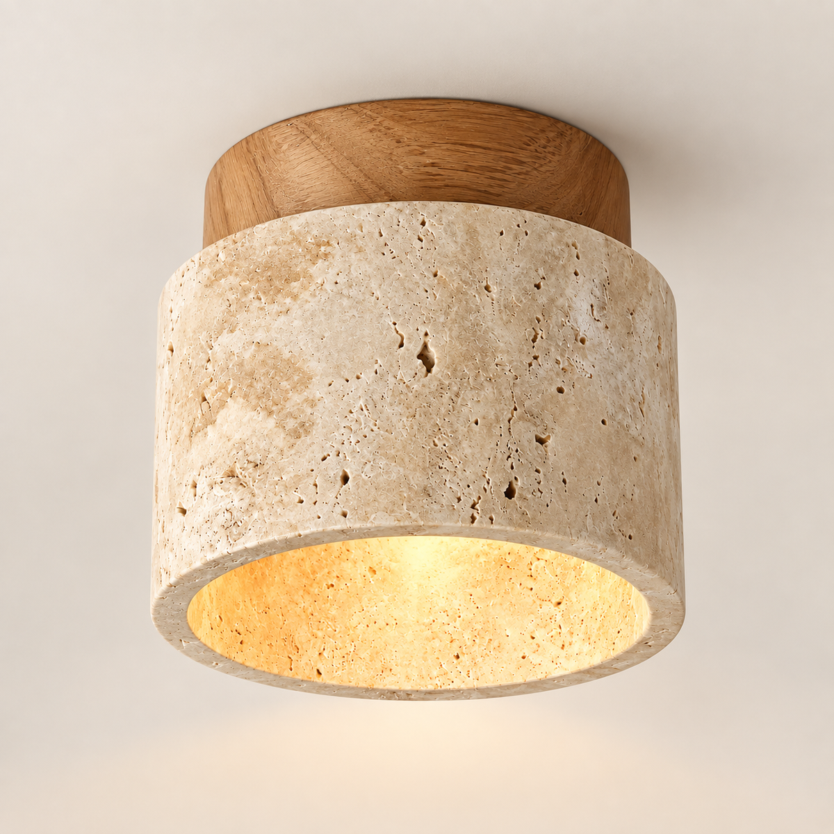 Calvera travertine and wood ceiling light, lit, on a greige studio background