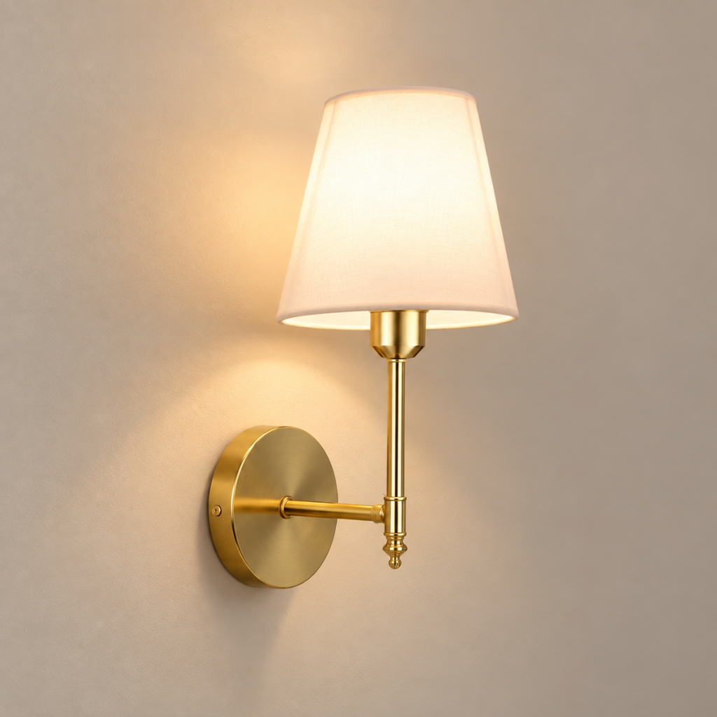 Elise cordless rechargeable wall light in brushed gold, lit, on a greige wall