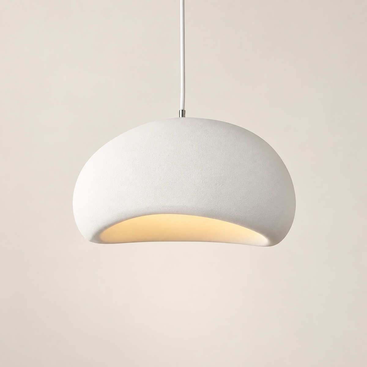 Kaela wabi-sabi dome pendant light in textured white, lit, on a greige studio background