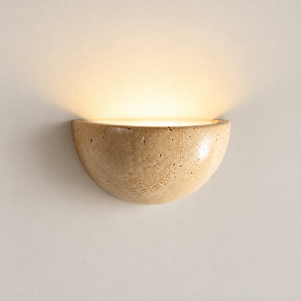 Lunara half-moon wall light in natural yellow travertine, washing light up a plaster wall