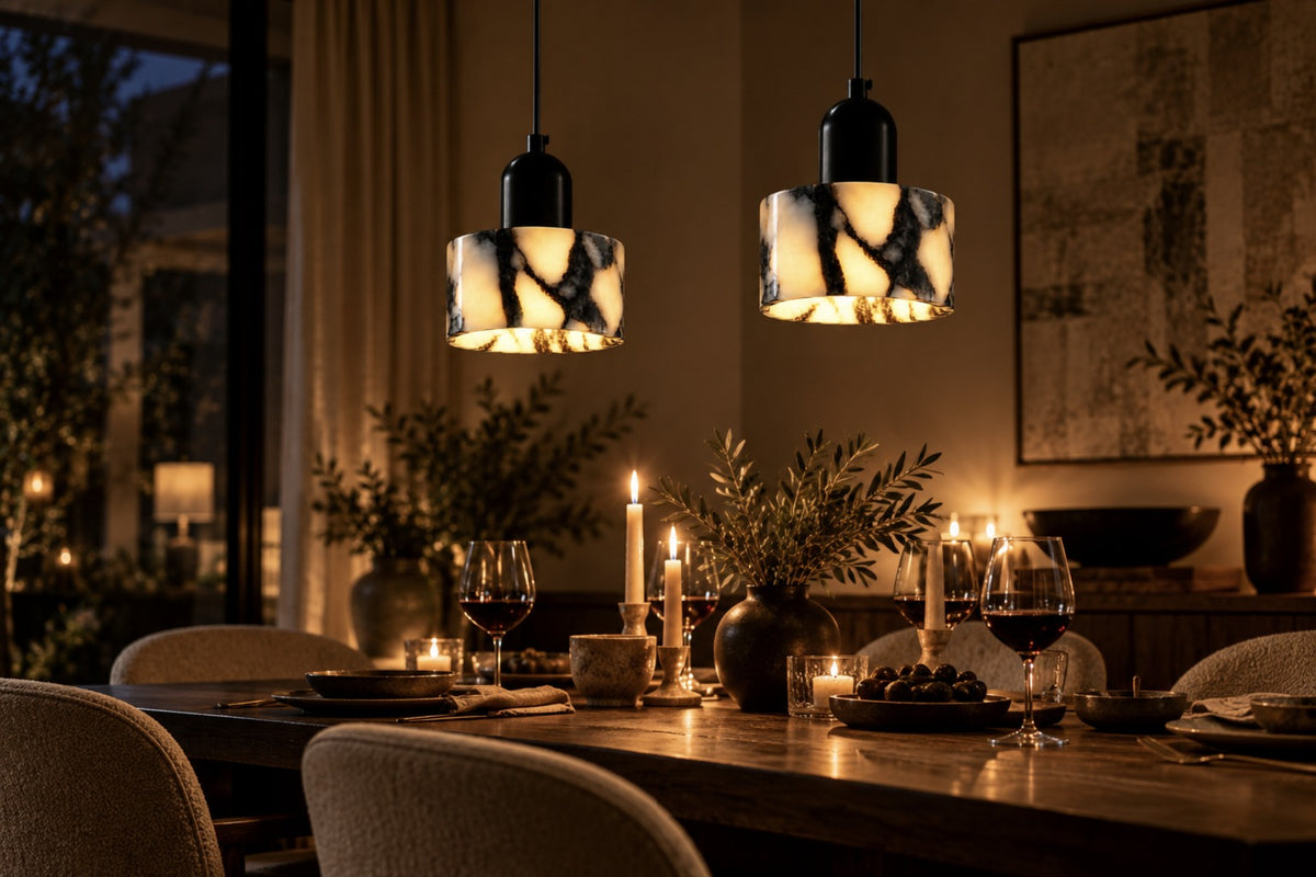 Two Marra stone pendants glowing above a candlelit dinner table