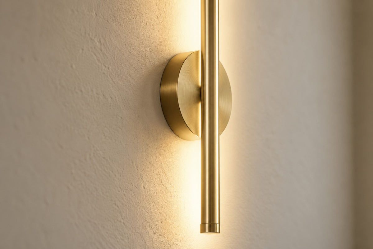 Close-up of the Orla brushed gold light bar and magnetic wall disc
