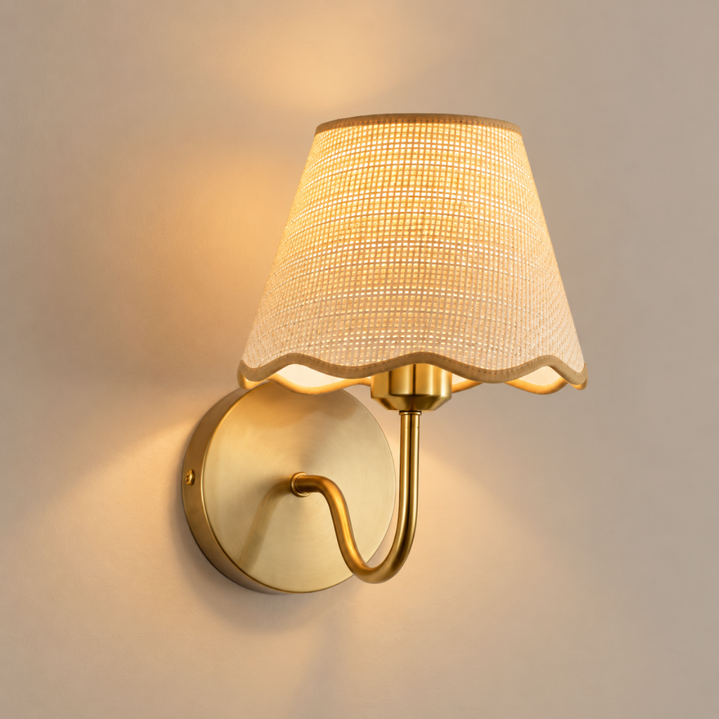 Paloma cordless rechargeable wall light with scalloped rattan shade, lit, on a greige wall