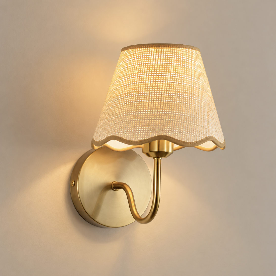 Paloma cordless rechargeable wall light with scalloped rattan shade, lit, on a greige wall