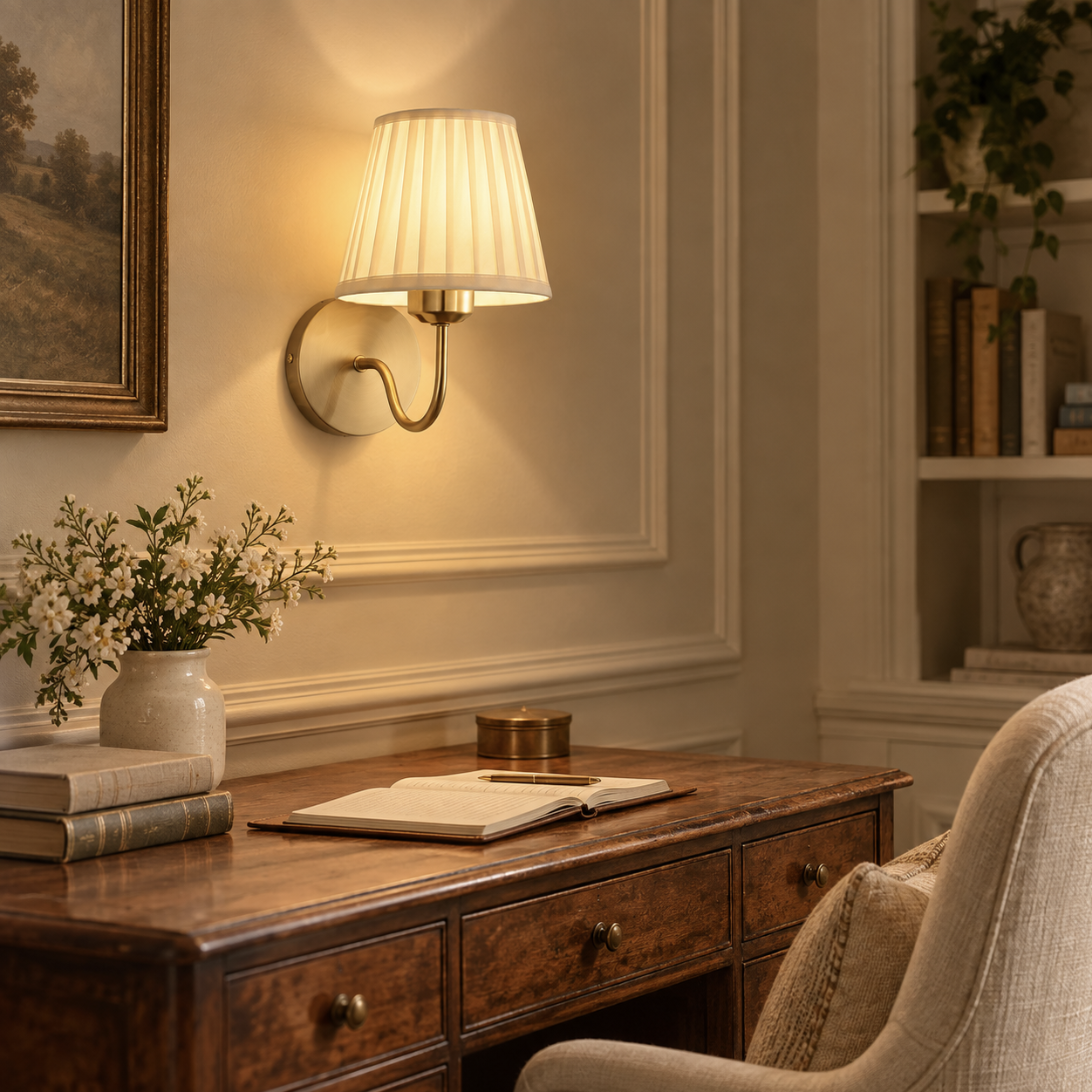 Rosalie brushed gold rechargeable wall light with cream pleated shade above a wooden desk