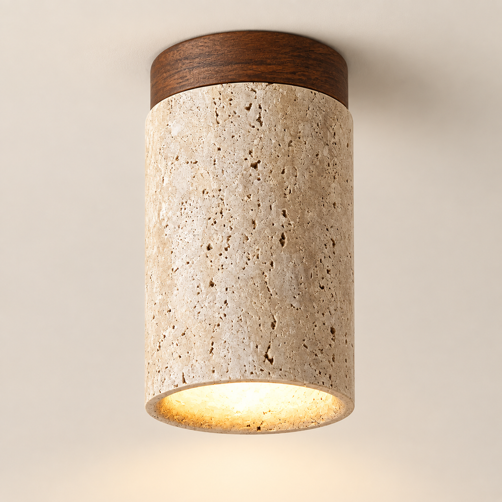Siena travertine ceiling light with walnut cap, lit, on a greige studio background