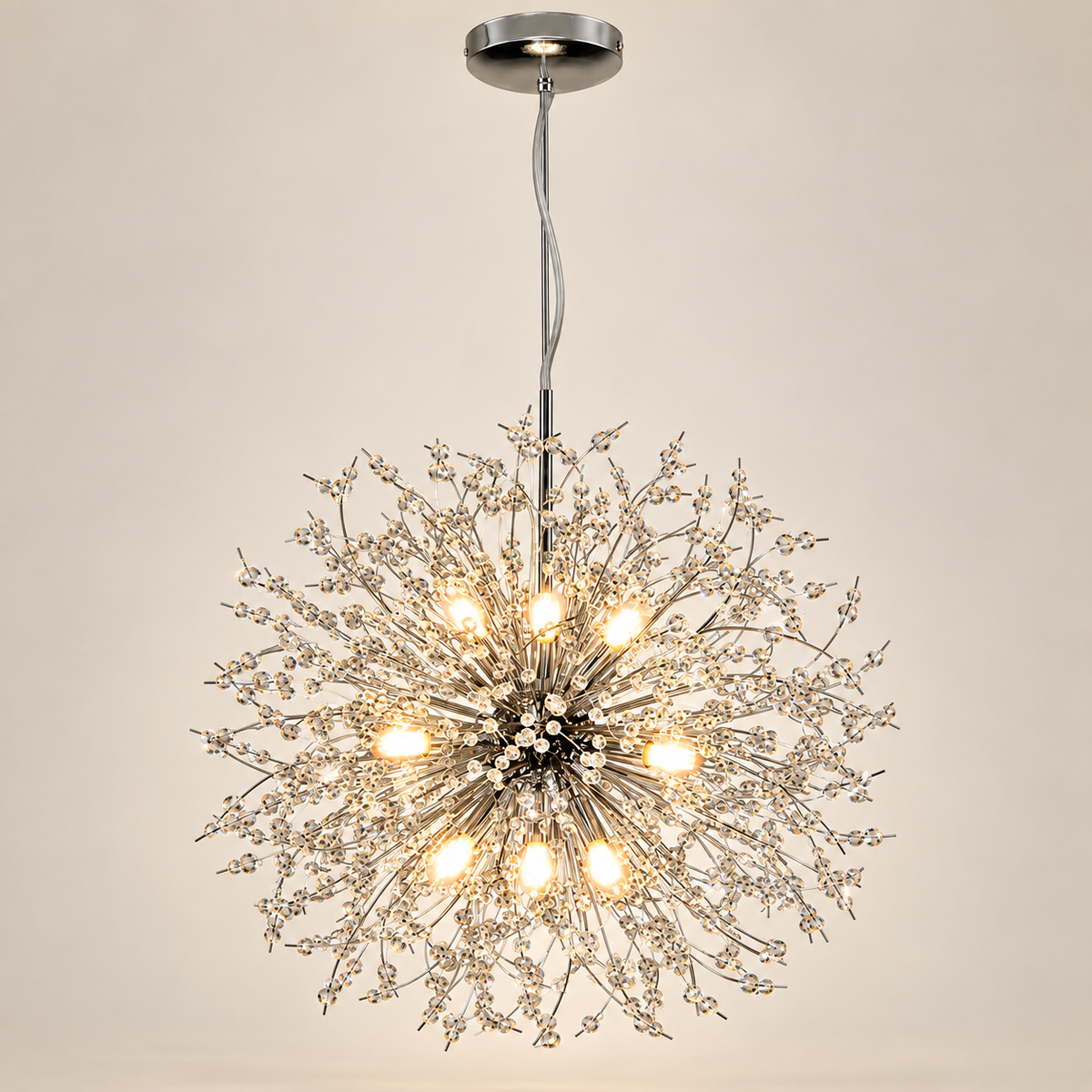 Stellia crystal dandelion chandelier in chrome, lit, on a greige studio background