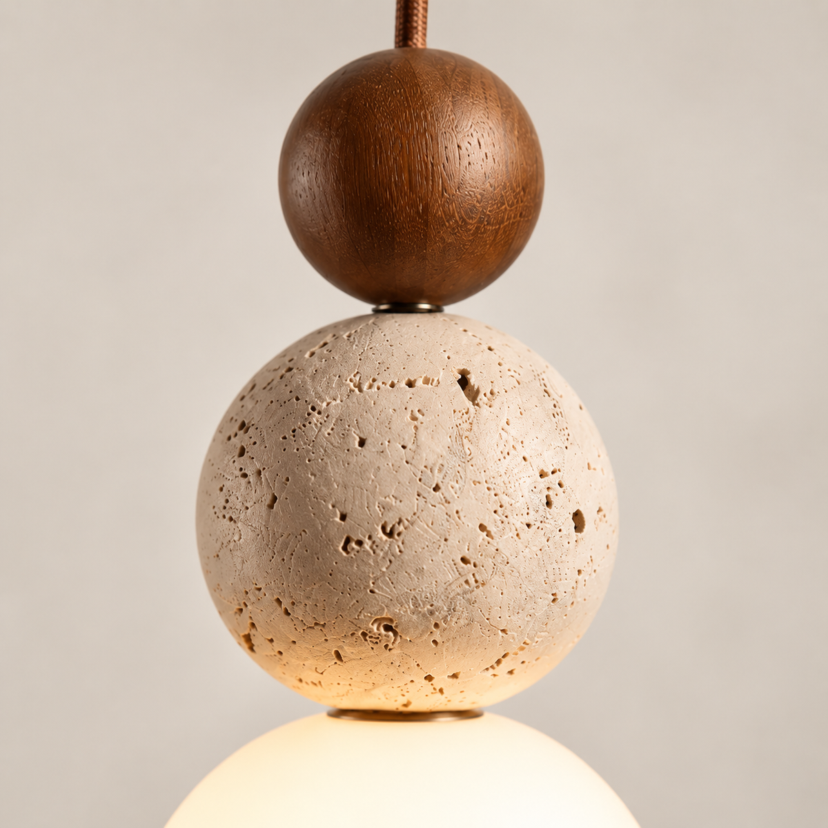 Close-up of the Terra walnut sphere, porous travertine and glass globe