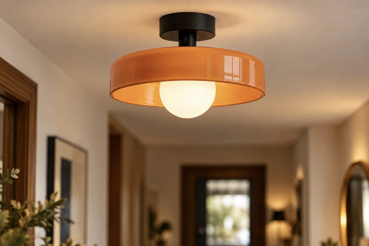 Close-up of the Vetra glossy orange glass shade and black stem, lit